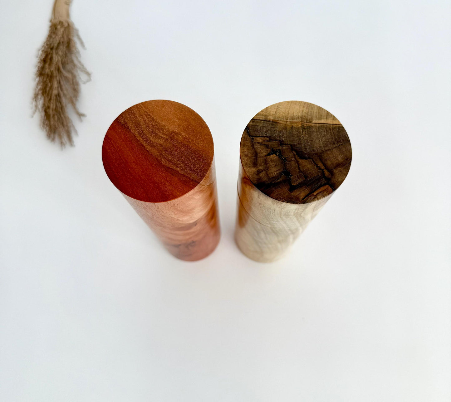 Birdseye view of wooden cylindrical shape salt and pepper grinders made from Australian river red gum and pistachio timbers