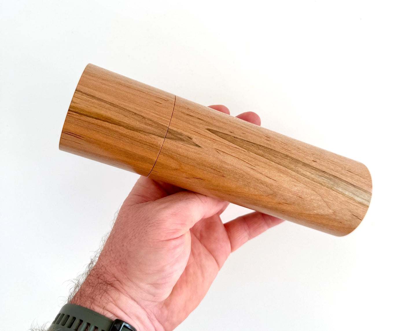Mans hand holding single straight Maple grinder