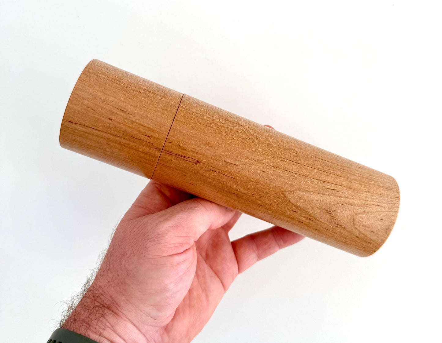 Mans hand holding single straight Maple grinder