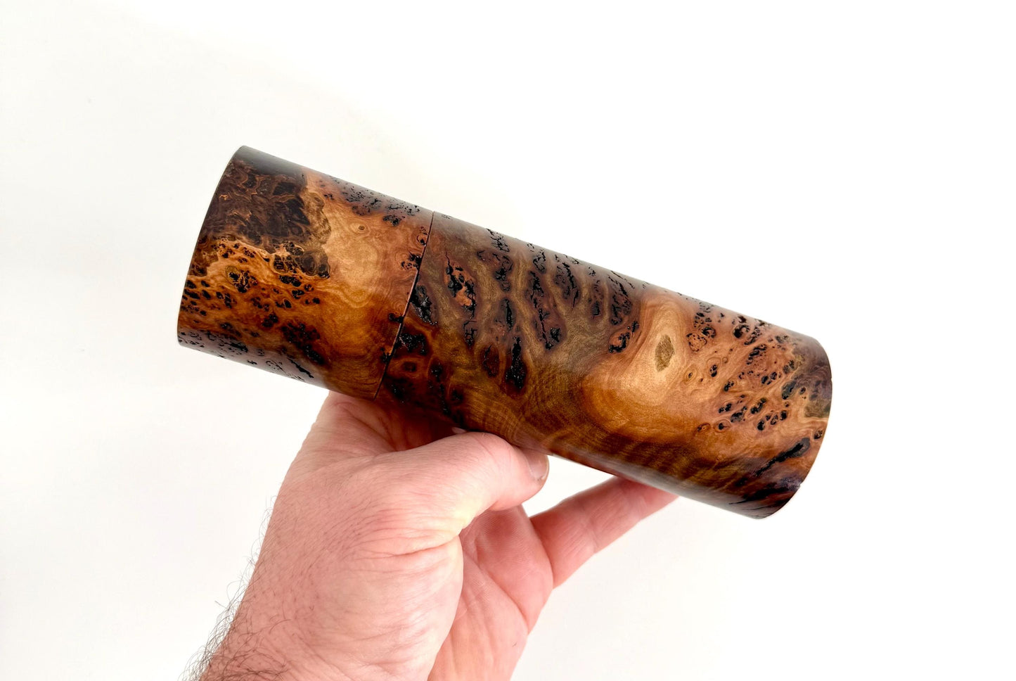 Mans hand holding single straight cylindrical Gimlet burl timber grinder