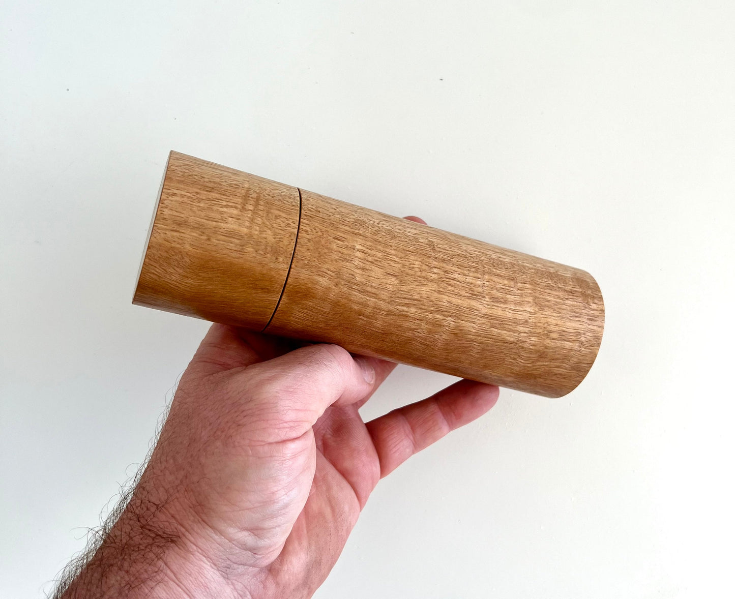 Mans hand hold a Blackbutt grinder on a white background