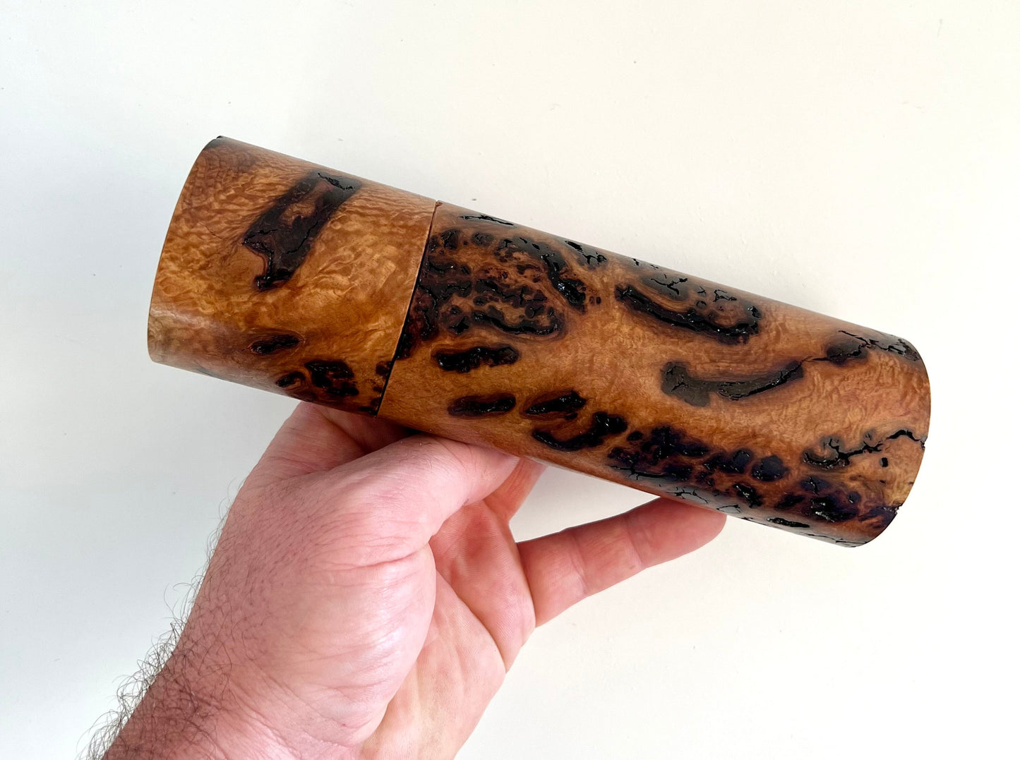 Mans hand holding single straight cylindrical bimble box grinder