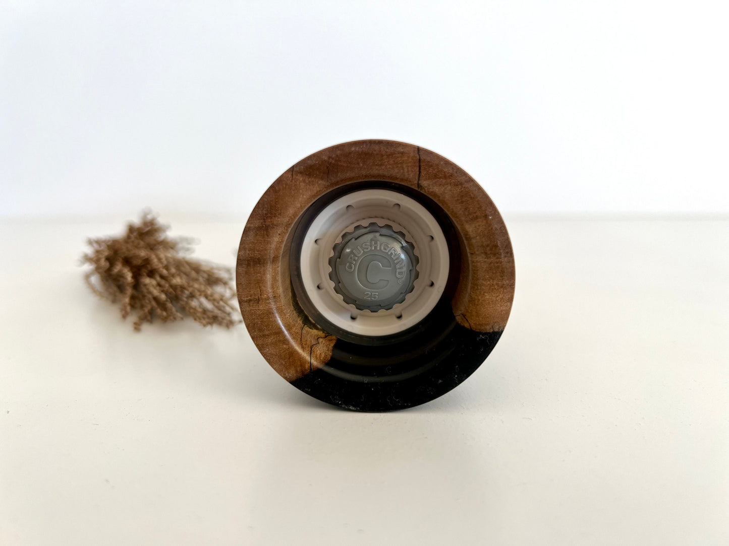 Bottom of salt and pepper grinder showing Crushgrind ceramic grinding mechanism and the adjustment knob