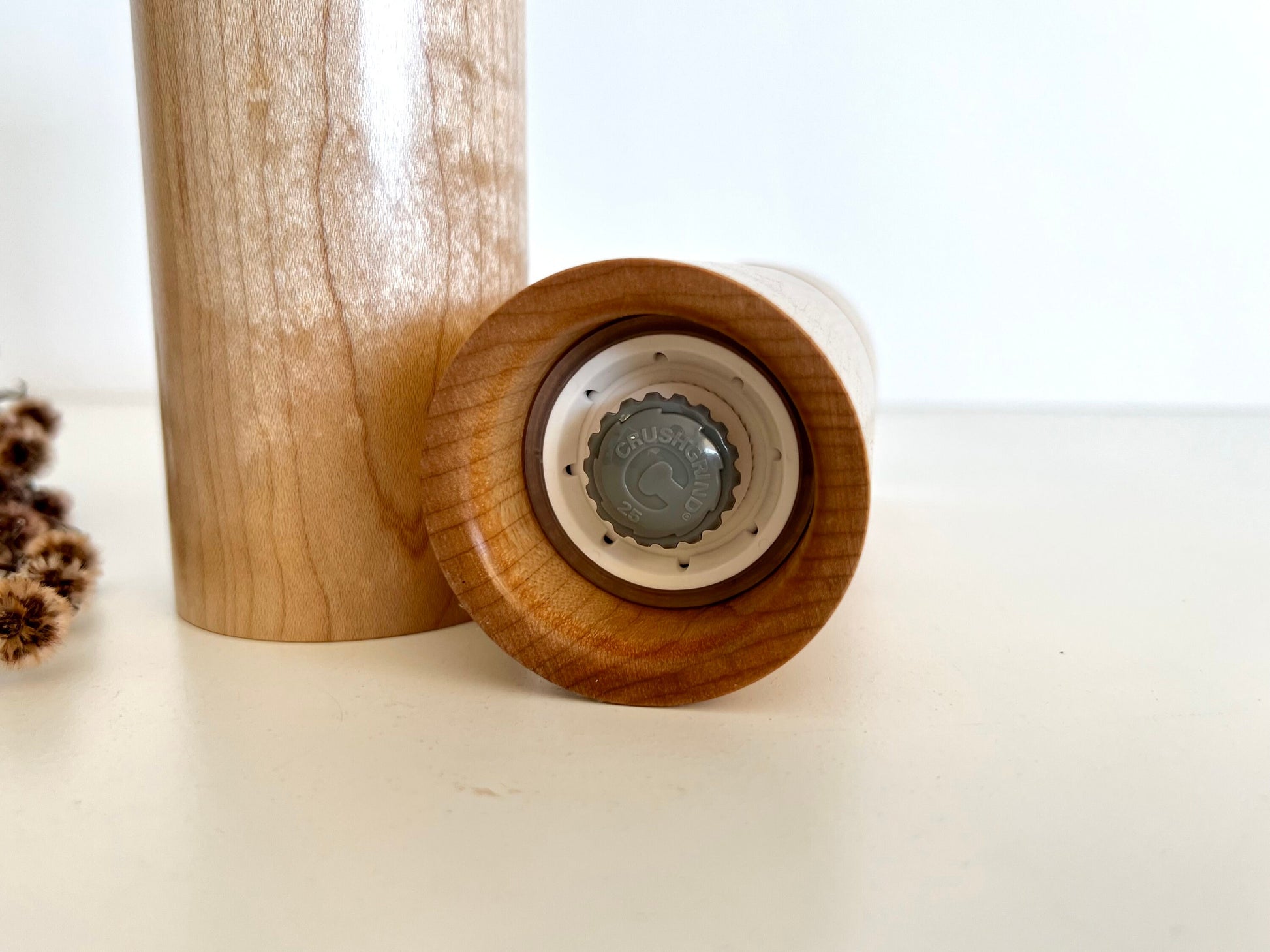 Bottom of salt and pepper grinder showing Crushgrind ceramic grinding mechanism and the adjustment knob