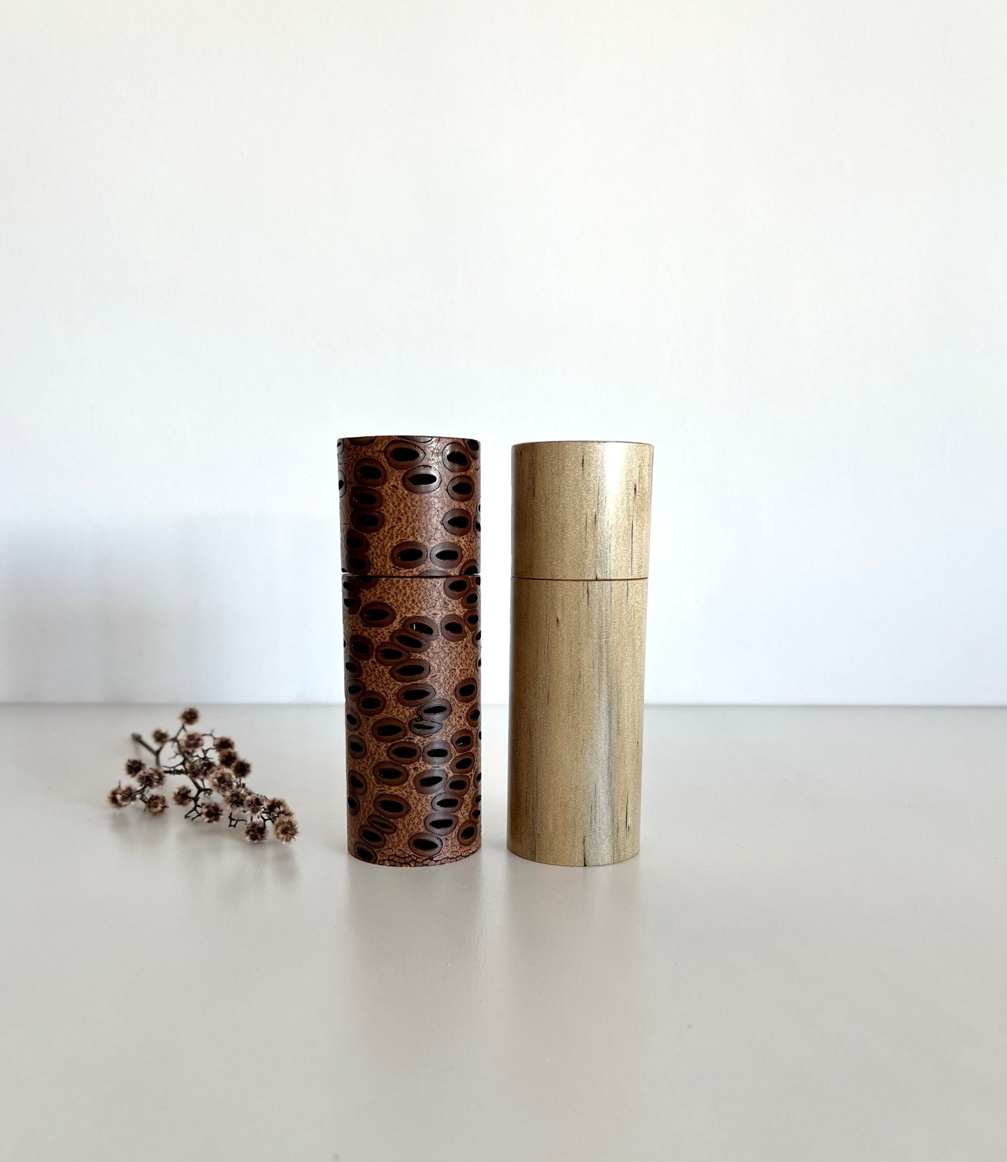 Wooden cylindrical shape salt and pepper grinders made from Australian Banksia seed pod and Norfolk island pine timbers