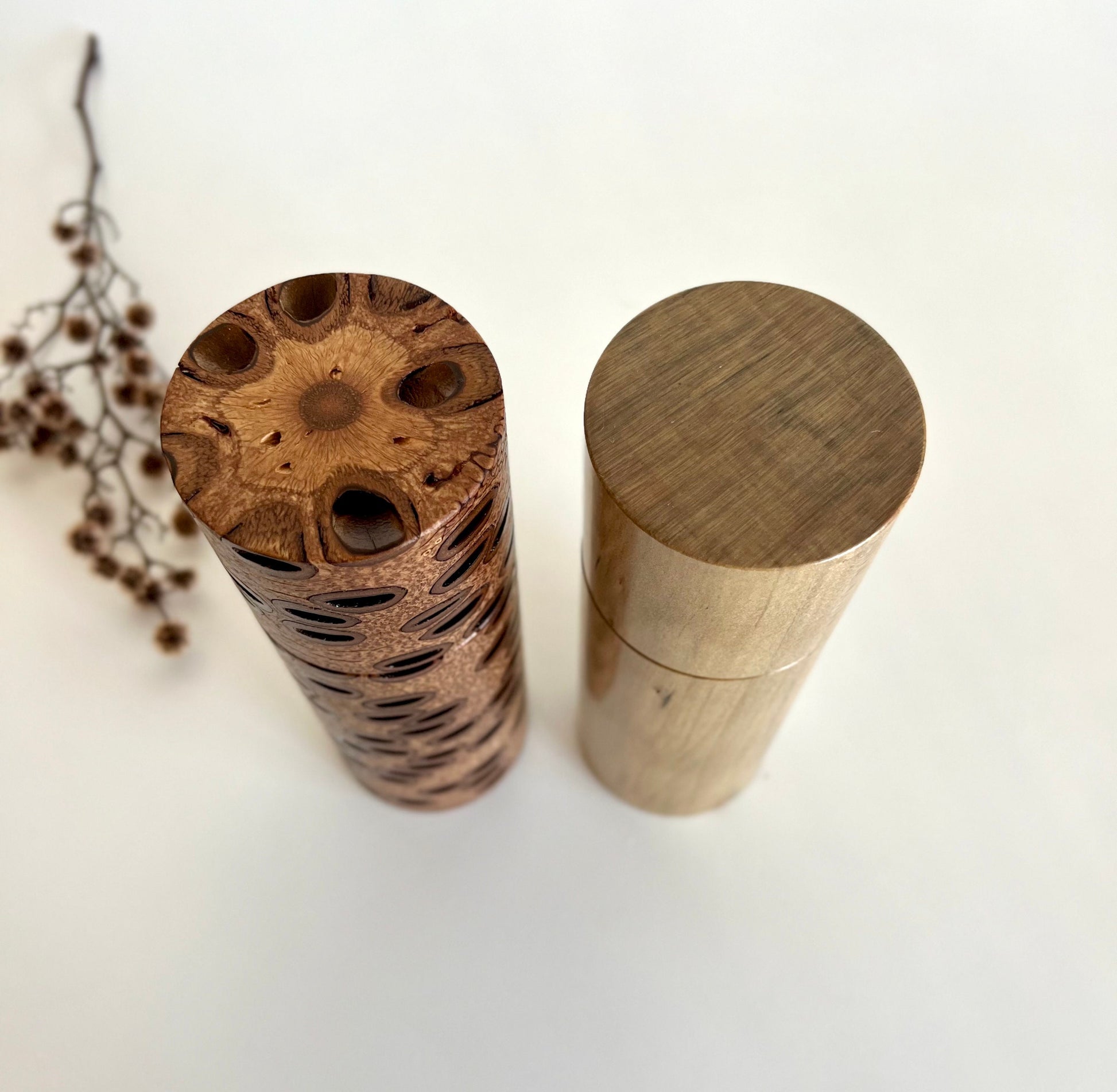 Birdseye view of wooden cylindrical shape salt and pepper grinders made from Australian Banksia seed pod and Norfolk island pine timbers.