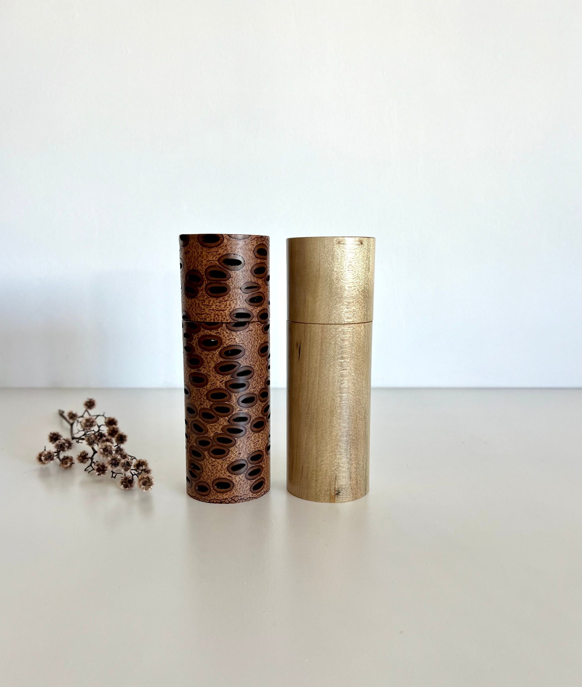 Wooden cylindrical shape salt and pepper grinders made from Australian Banksia seed pod and Norfolk island pine timbers