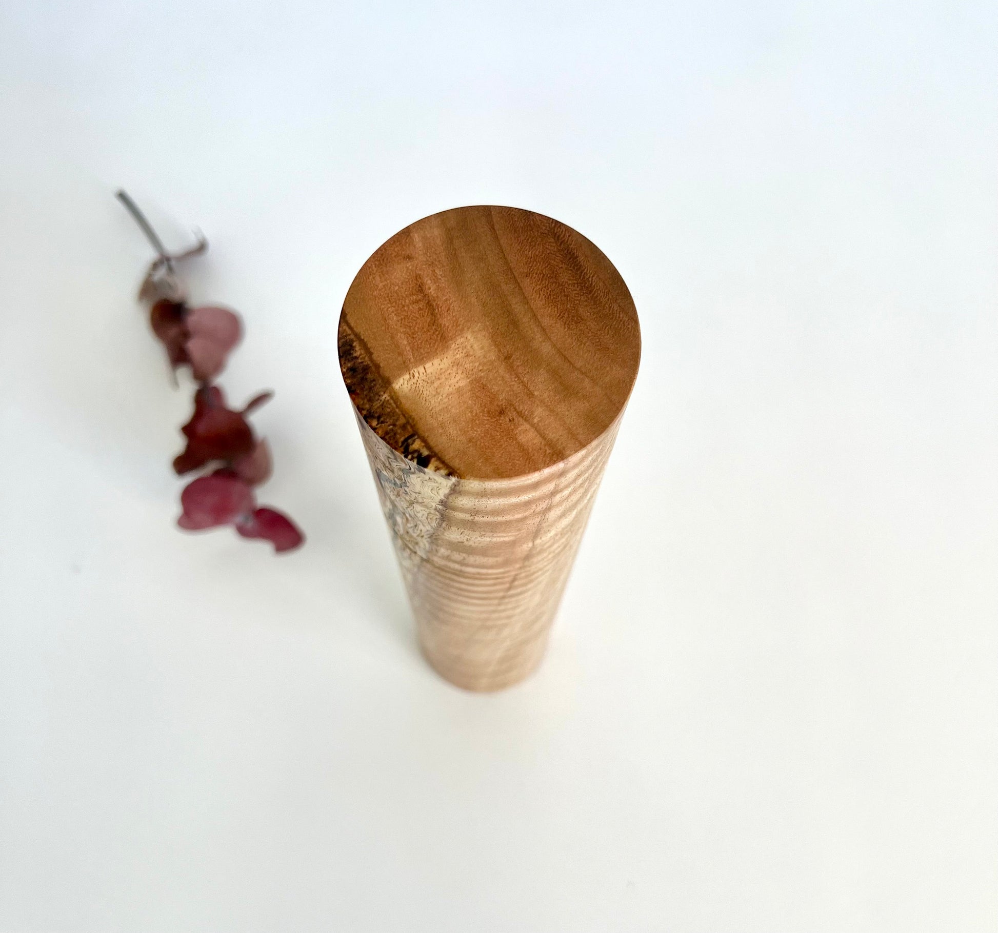 Birdseye view of wooden cylindrical shape salt and pepper grinder made from Australian Manna gum timber.