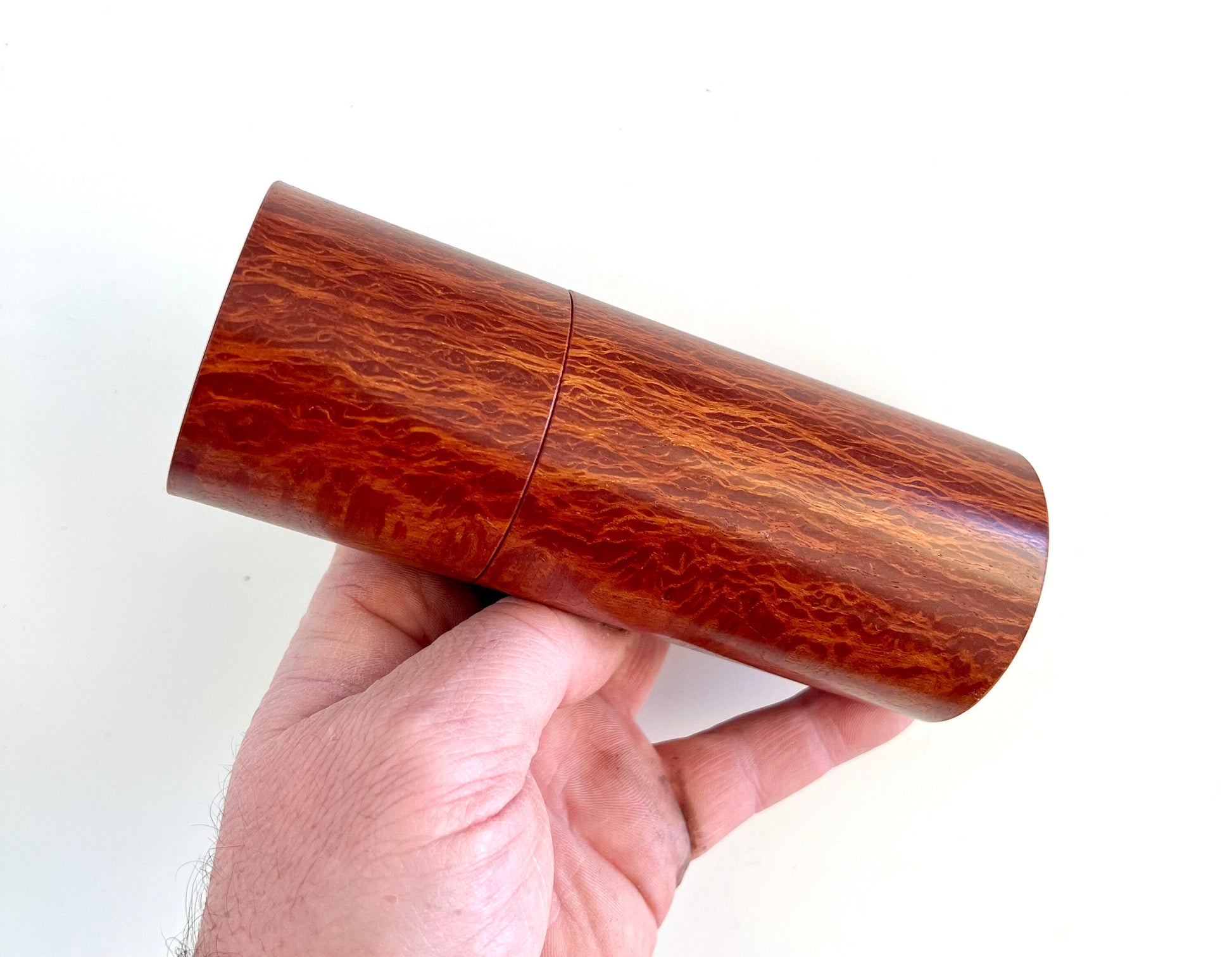 Mans hand holding single straight cylindrical Lace Sheoak grinder