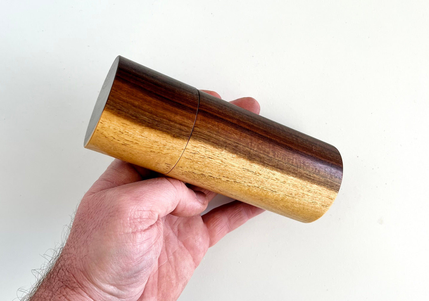 Mans hand holding single straight cylindrical Western Myall timber grinder