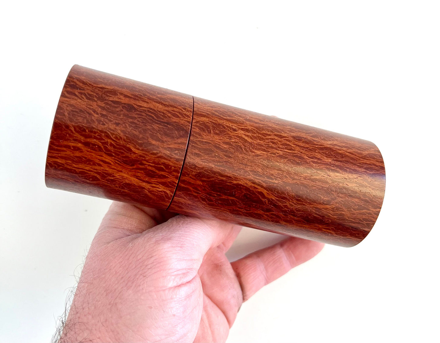 Mans hand holding single straight cylindrical Lace Sheoak grinder