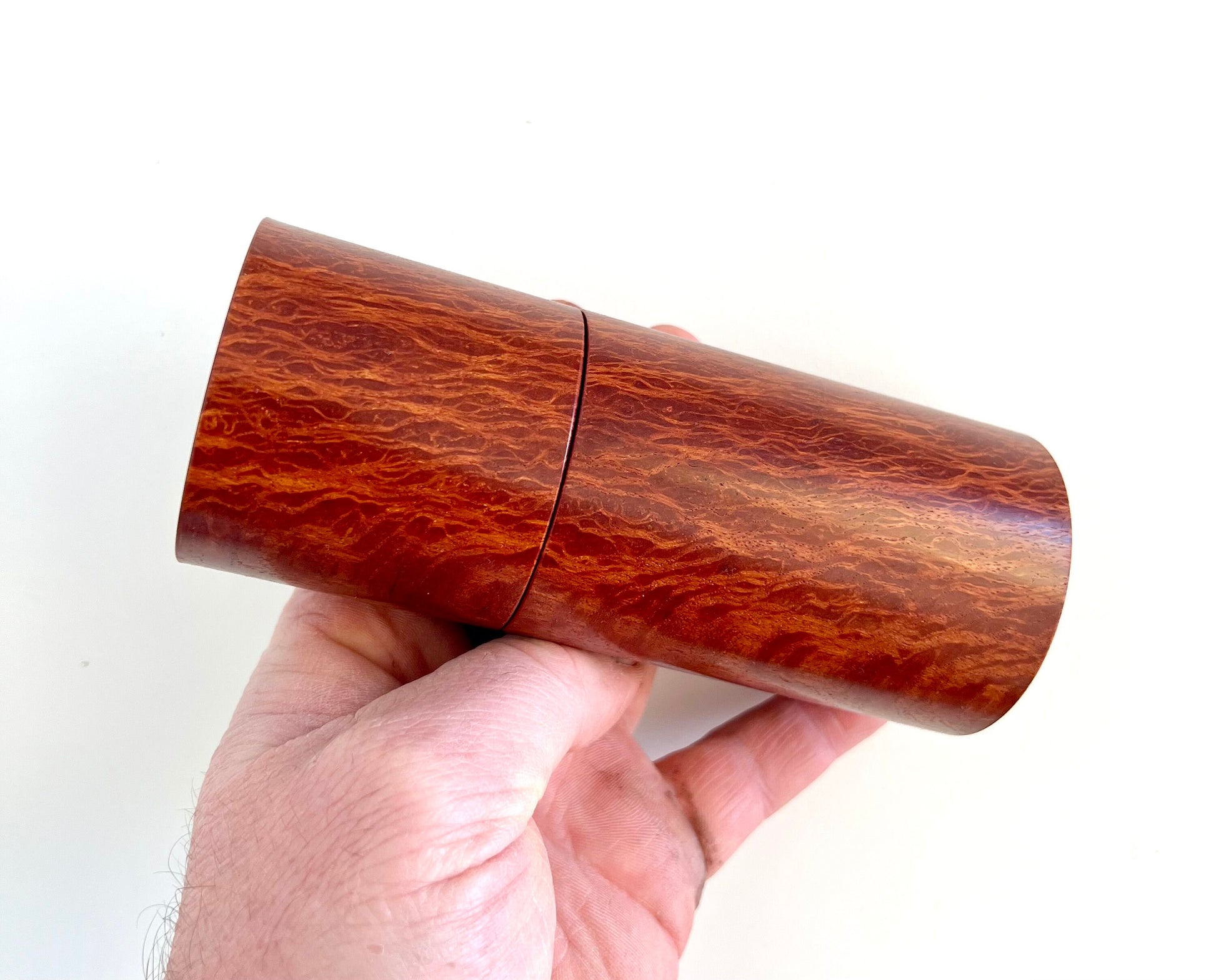 Mans hand holding single straight cylindrical Lace Sheoak grinder