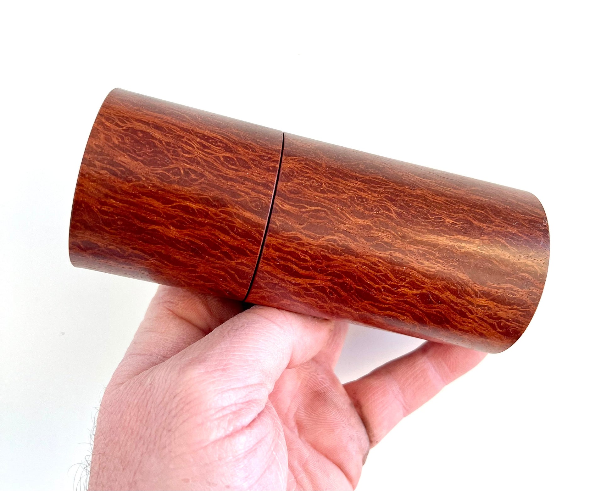 Mans hand holding single straight cylindrical Lace Sheoak grinder