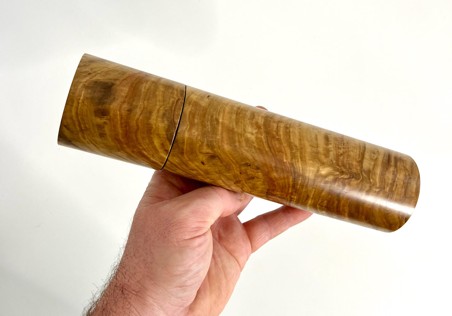 Mans hand holding single straight cylindrical Bimble Box Burl timber grinder