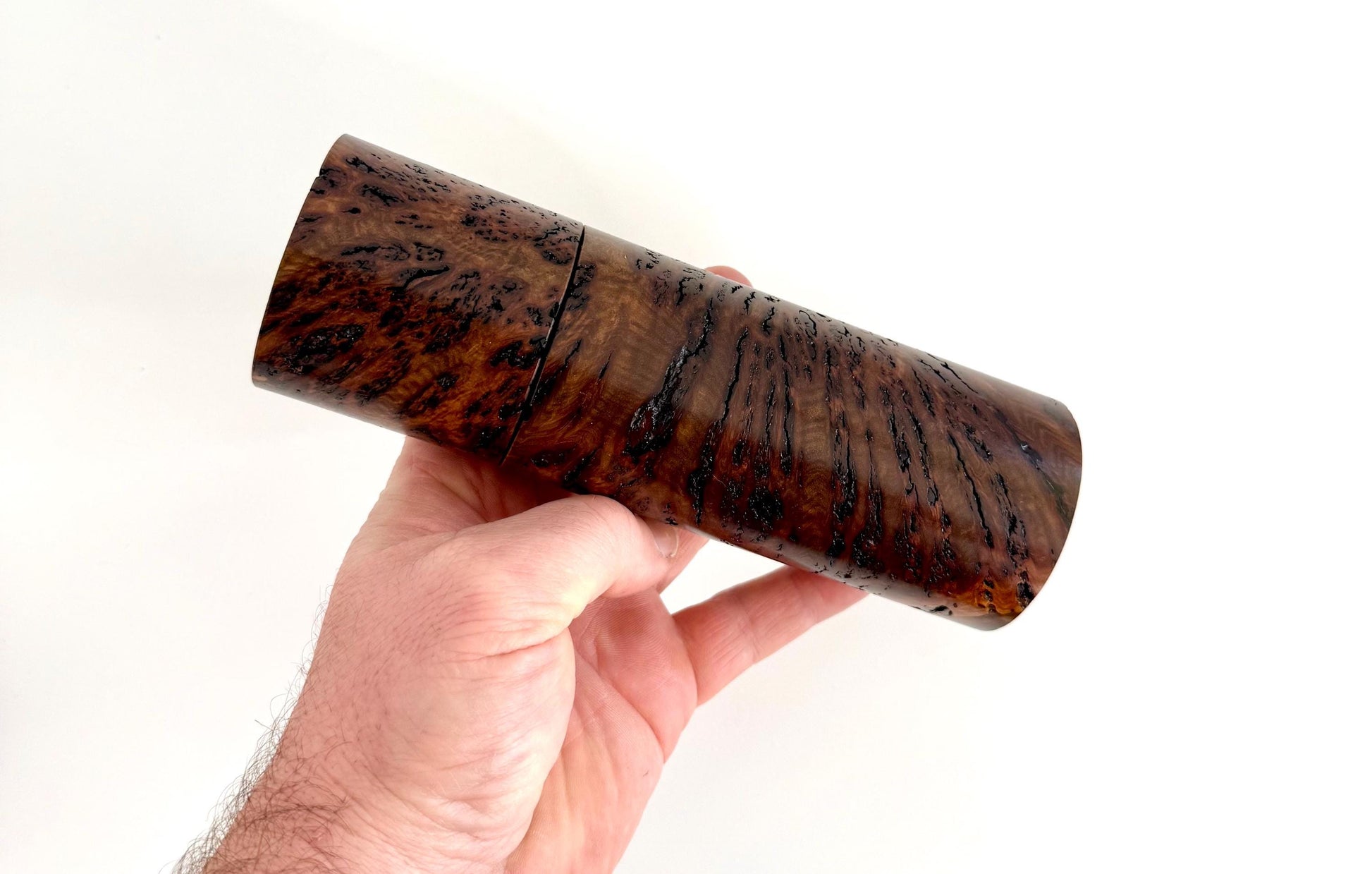 Mans hand holding single straight cylindrical Gimlet burl timber grinder