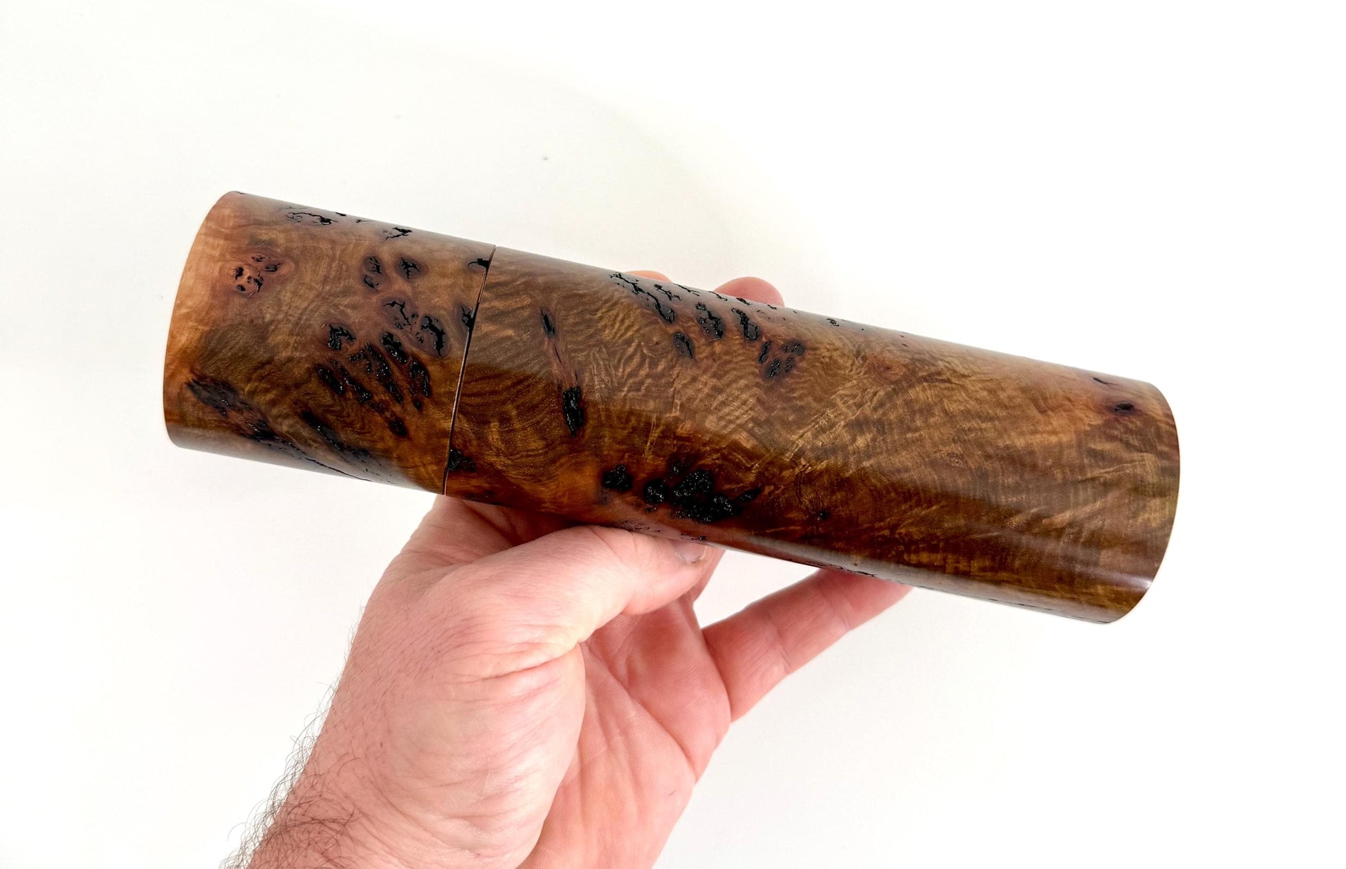 Mans hand holding single straight cylindrical Gimlet burl timber grinder