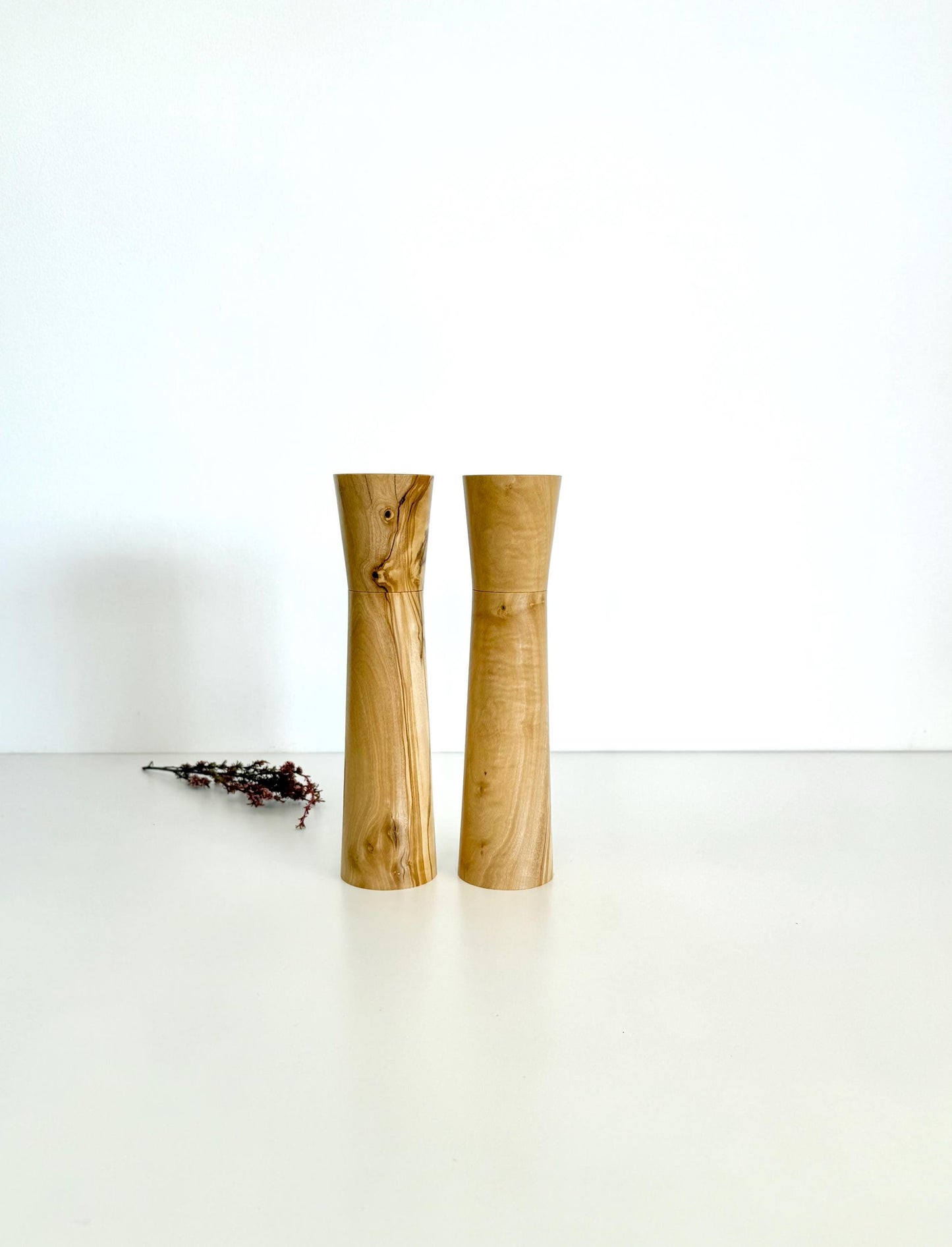 Wooden cylindrical shape salt and pepper grinders made from light brown patterned timber