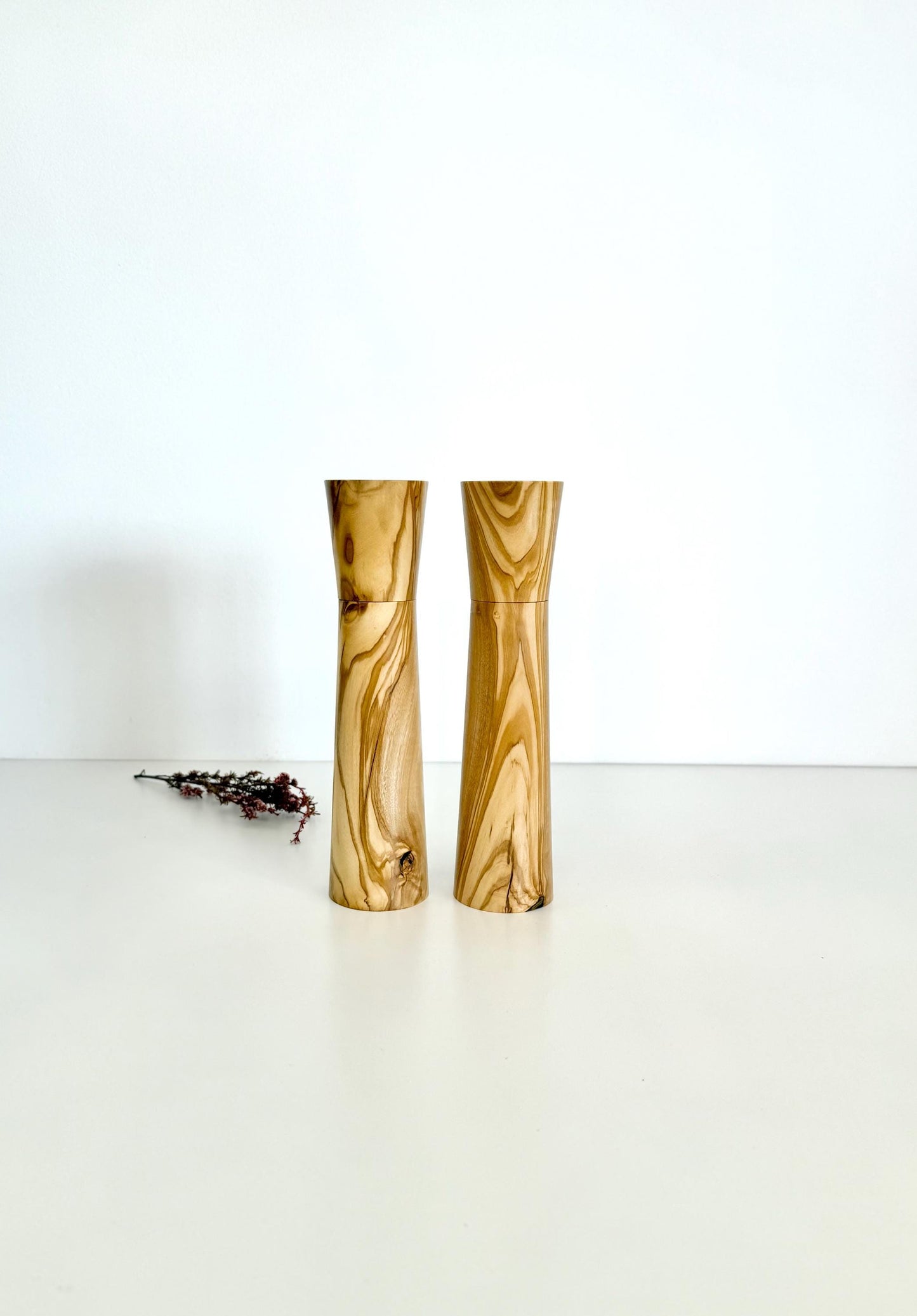 Wooden cylindrical shape salt and pepper grinders made from light brown patterned timber