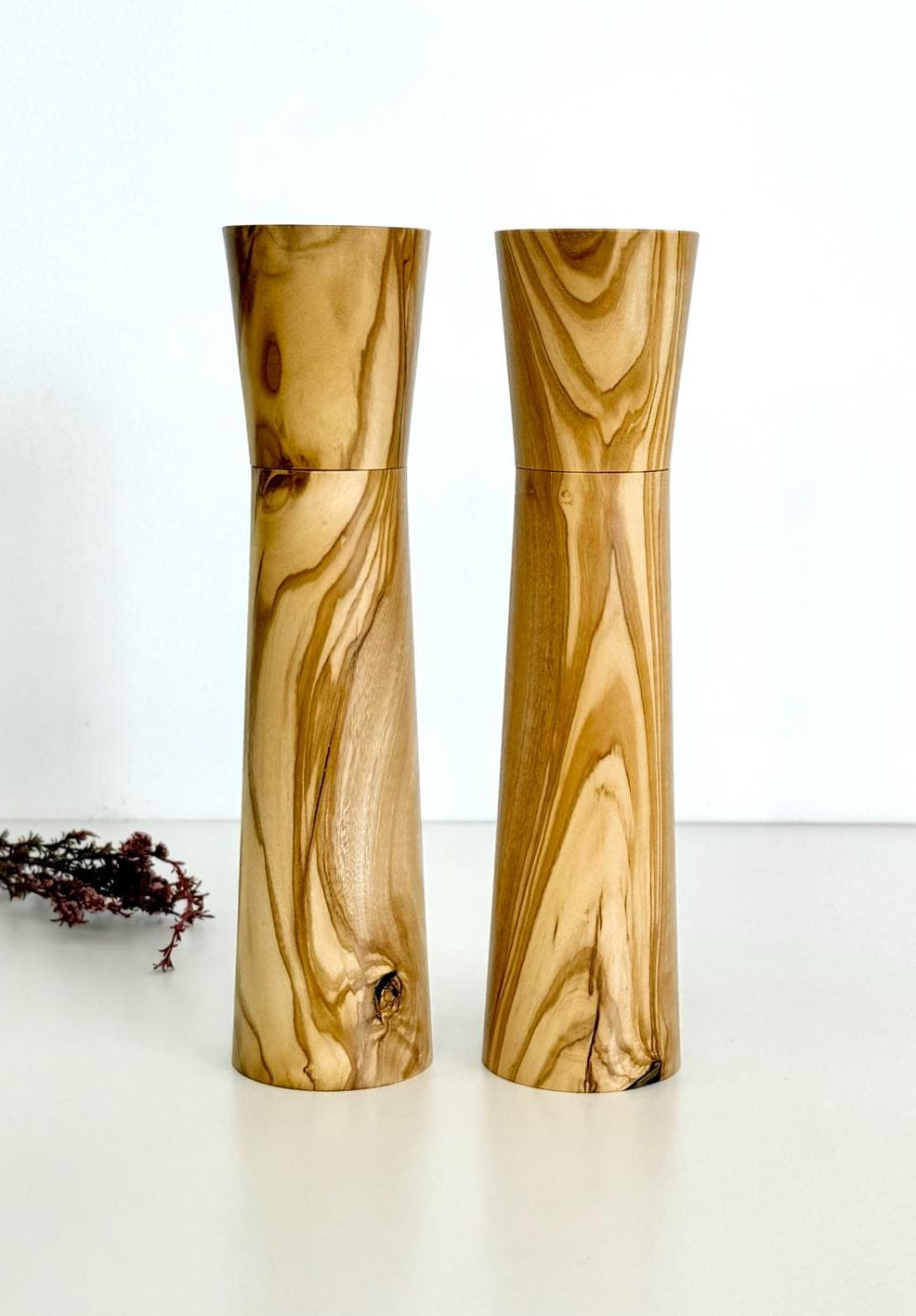 Wooden cylindrical shape salt and pepper grinders made from light brown patterned timber