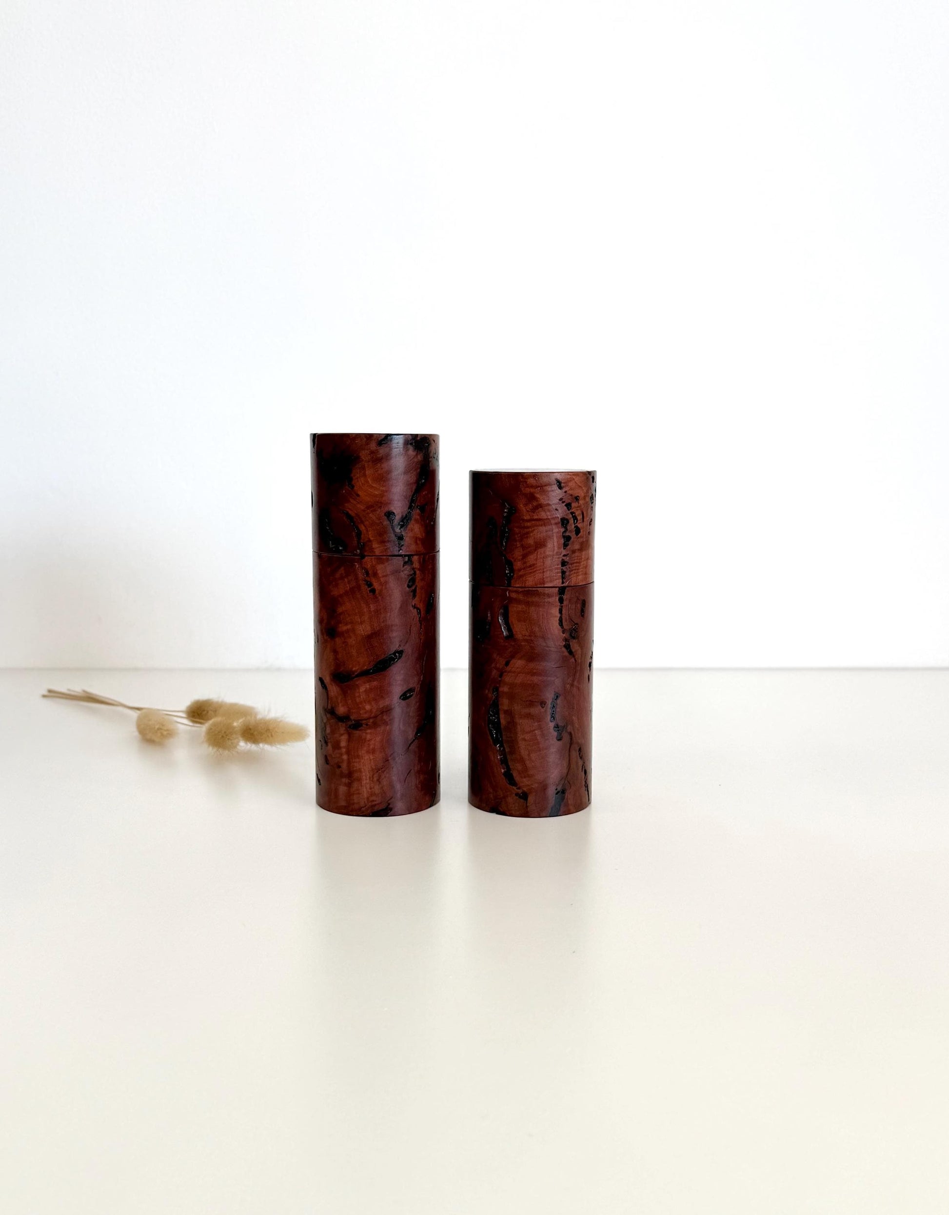 Wooden cylindrical shape salt and pepper grinders made from dark red burl timber