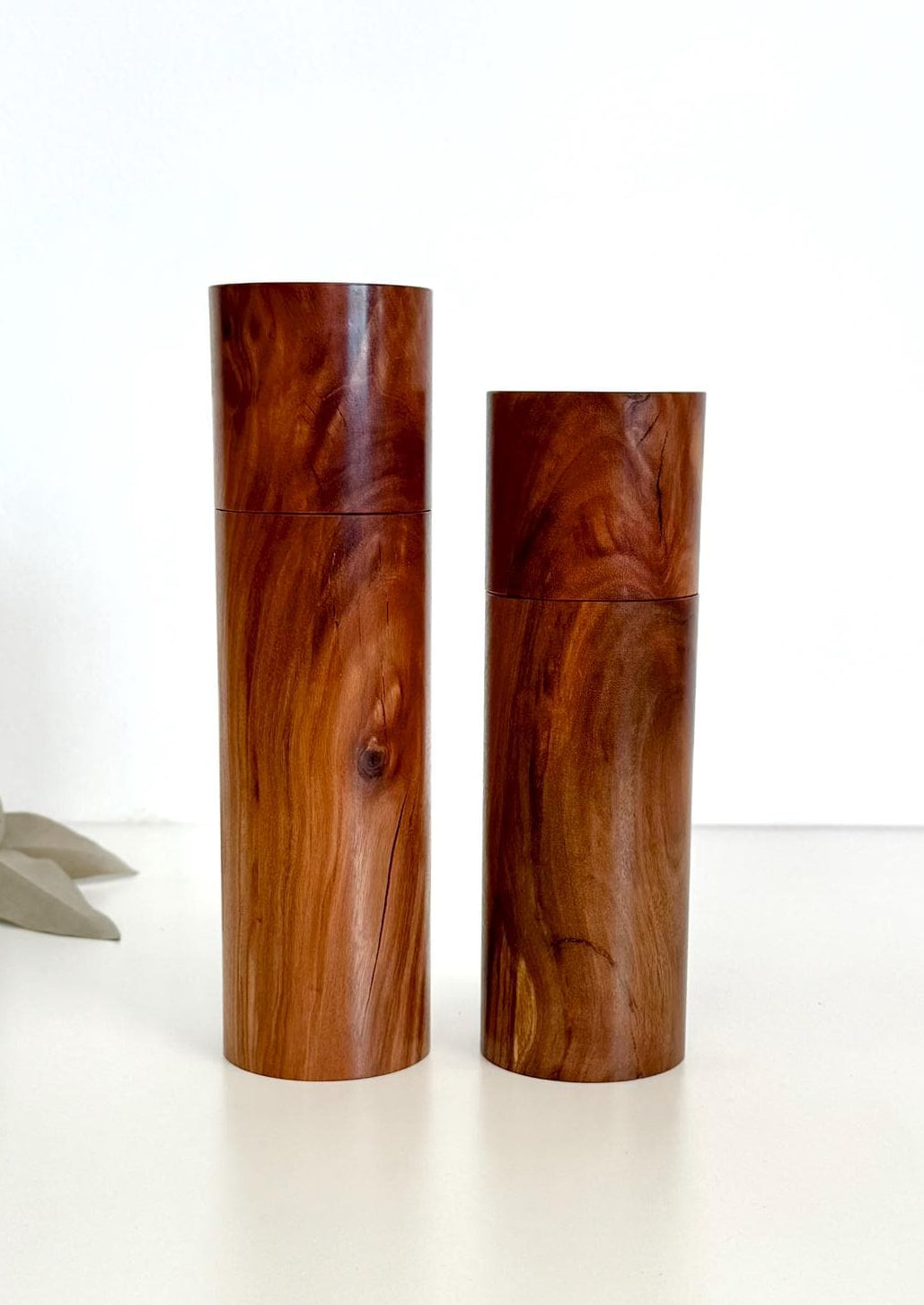 Wooden cylindrical shape salt and pepper grinders made from brown timber