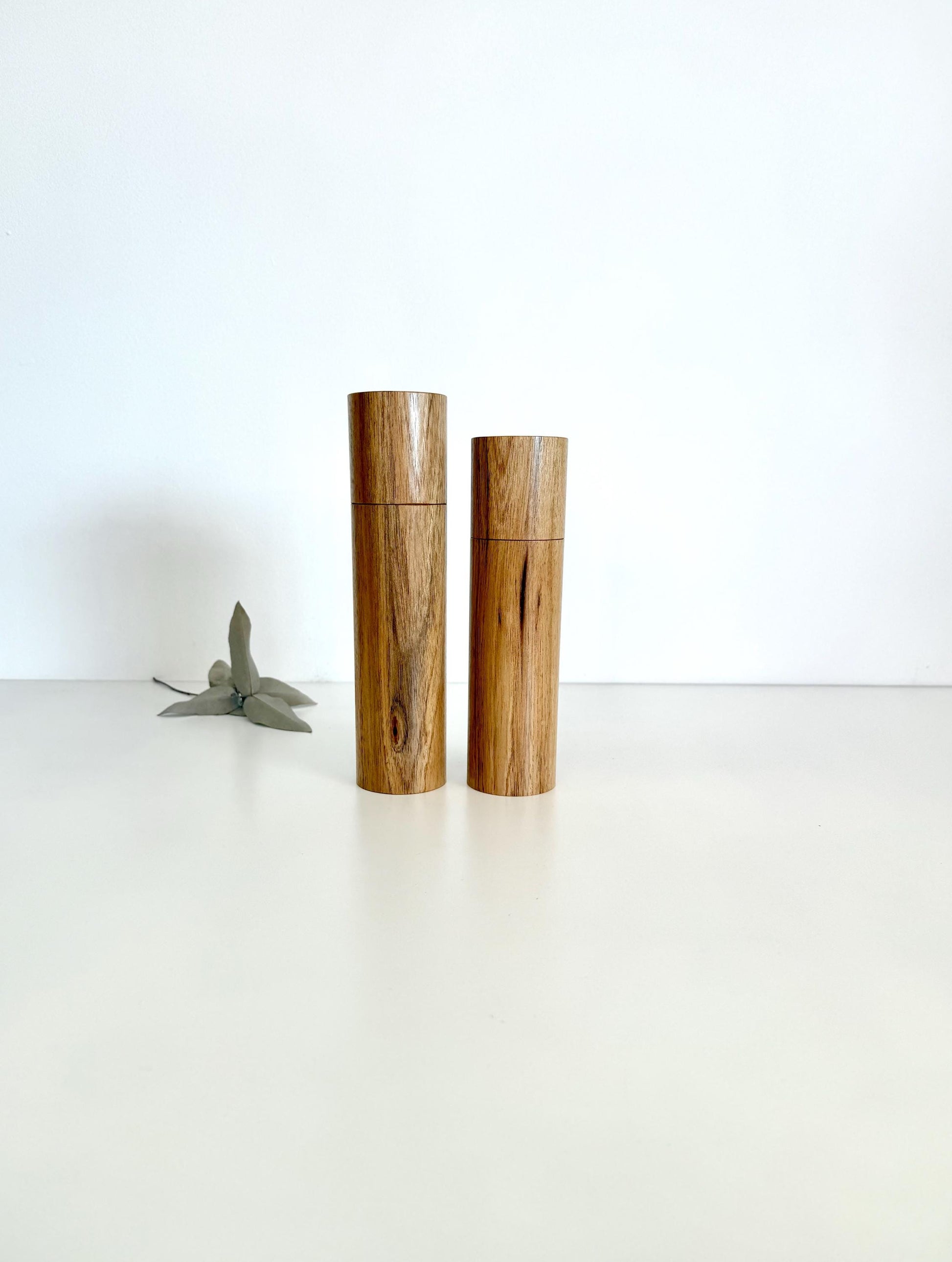 Wooden cylindrical shape salt and pepper grinders made from light brown timber