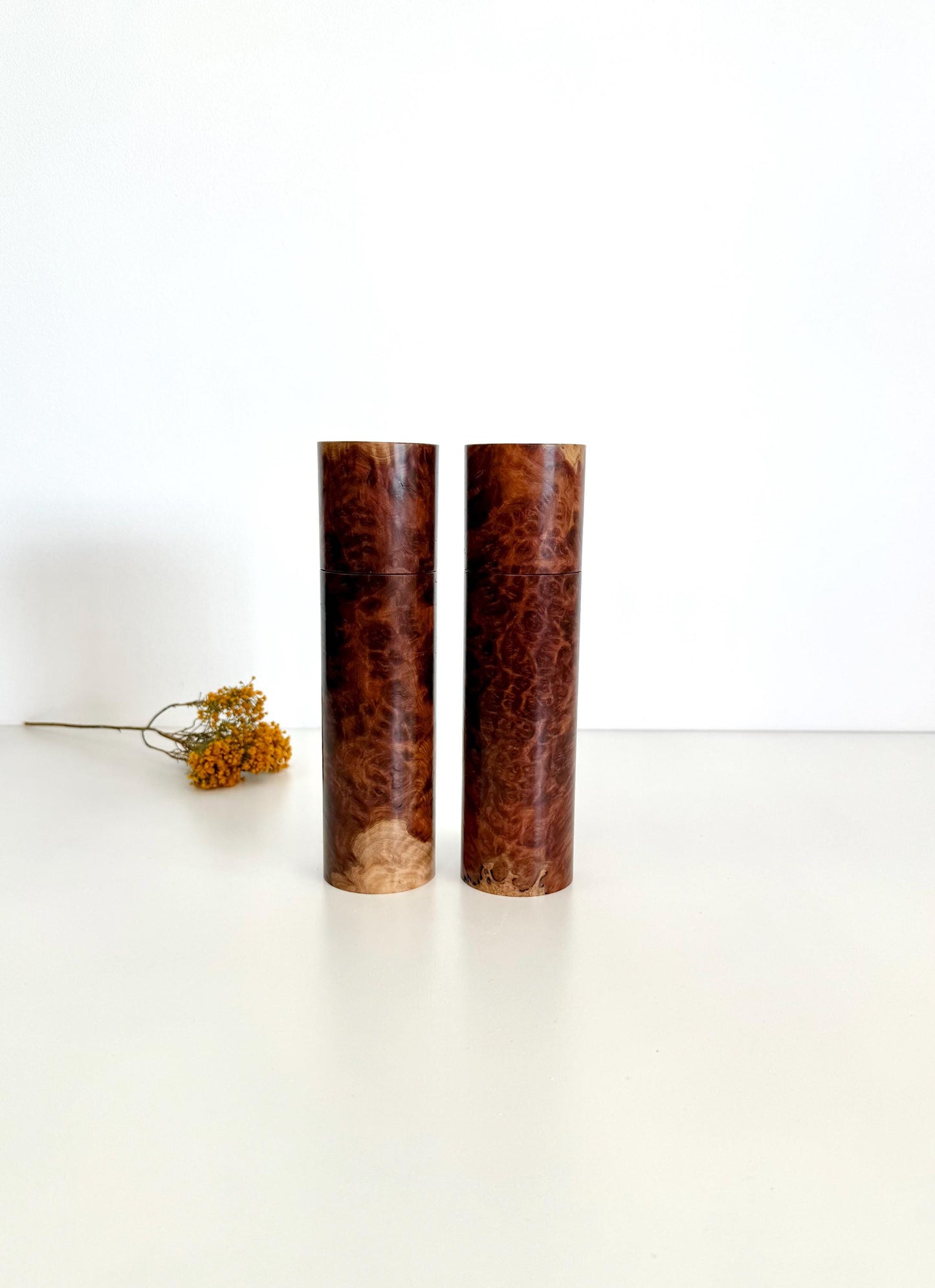 Wooden cylindrical shape salt and pepper grinders made from red burl timber