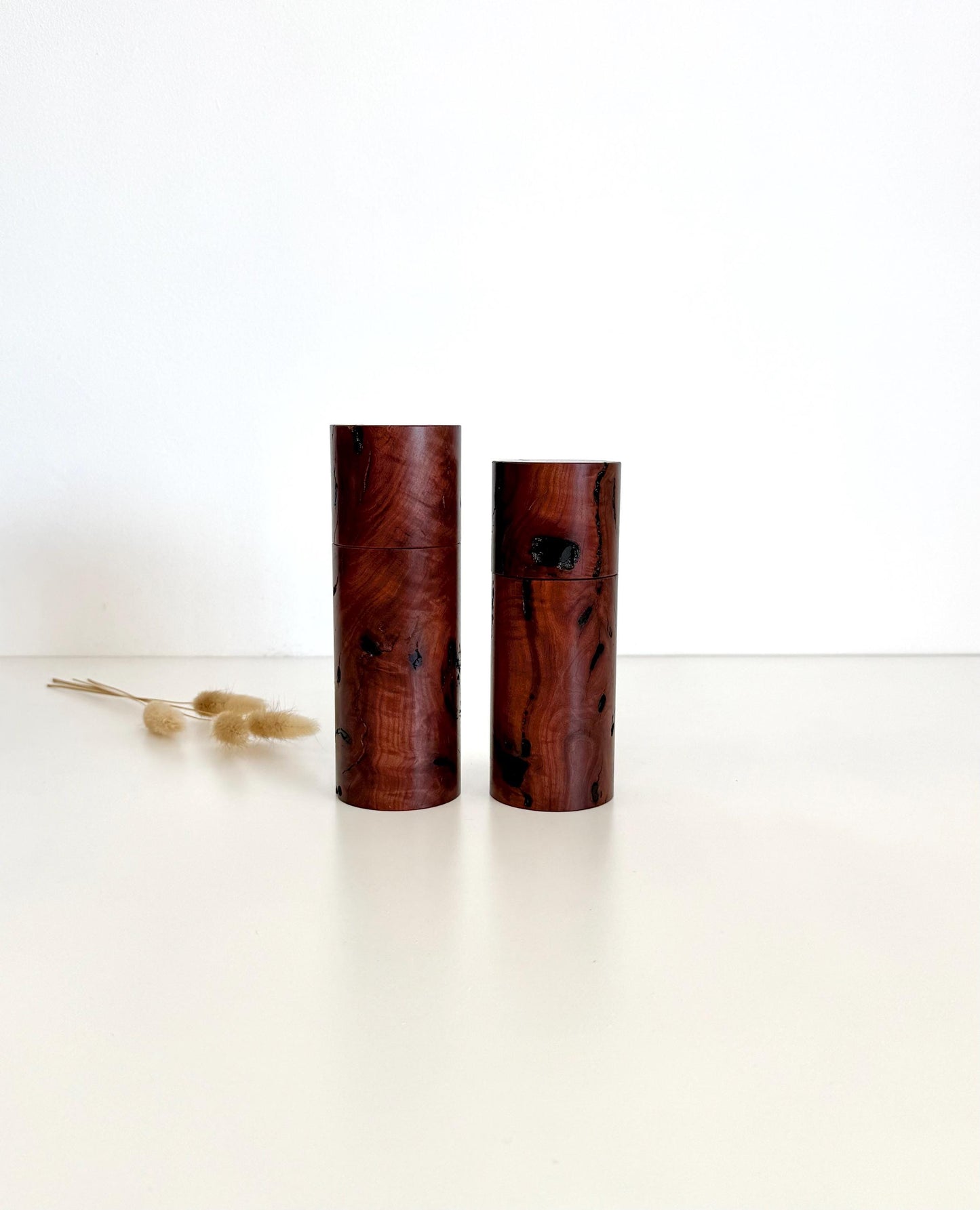 Wooden cylindrical shape salt and pepper grinders made from dark red burl timber