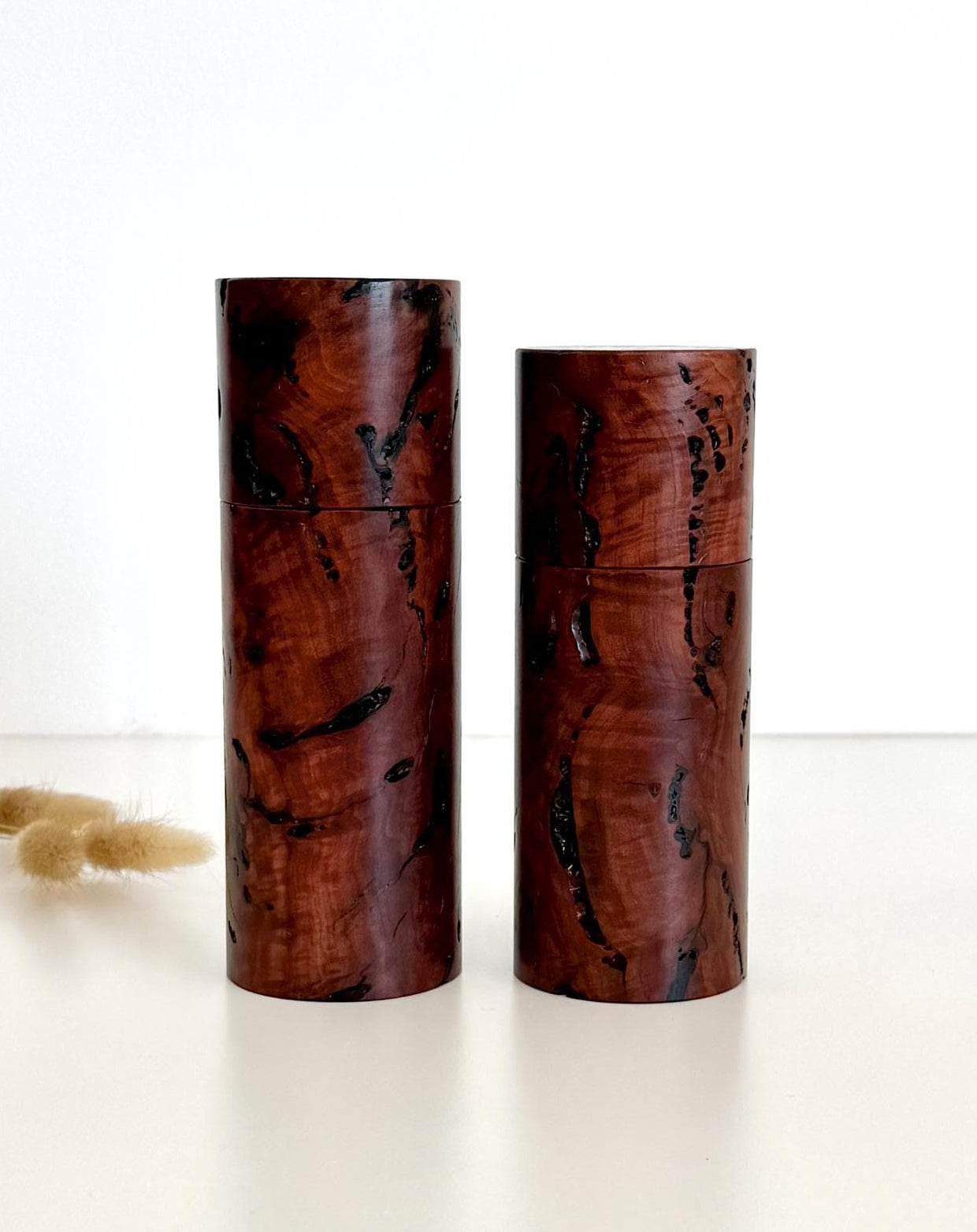 Wooden cylindrical shape salt and pepper grinders made from dark red burl timber