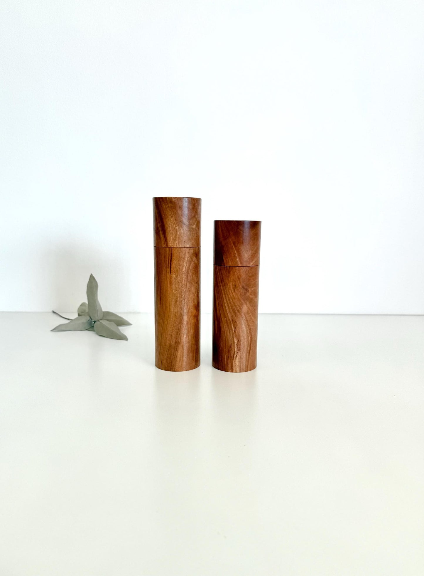 Wooden cylindrical shape salt and pepper grinders made from brown timber