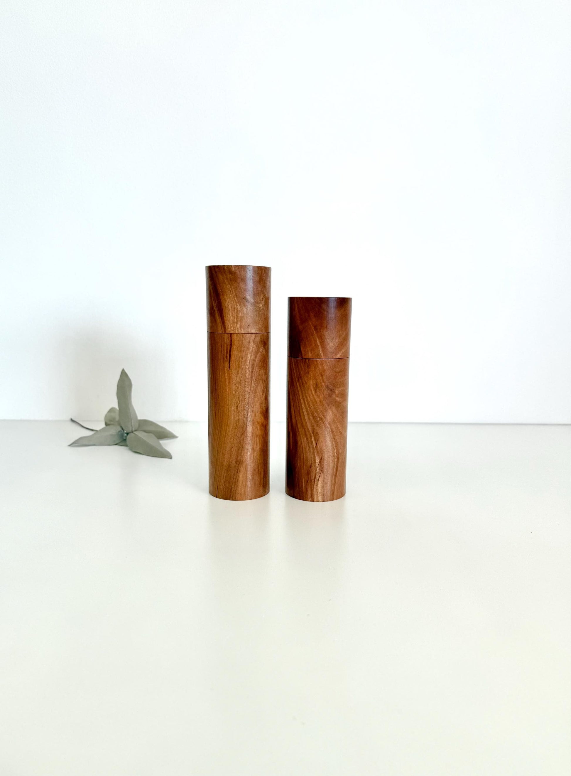 Wooden cylindrical shape salt and pepper grinders made from brown timber