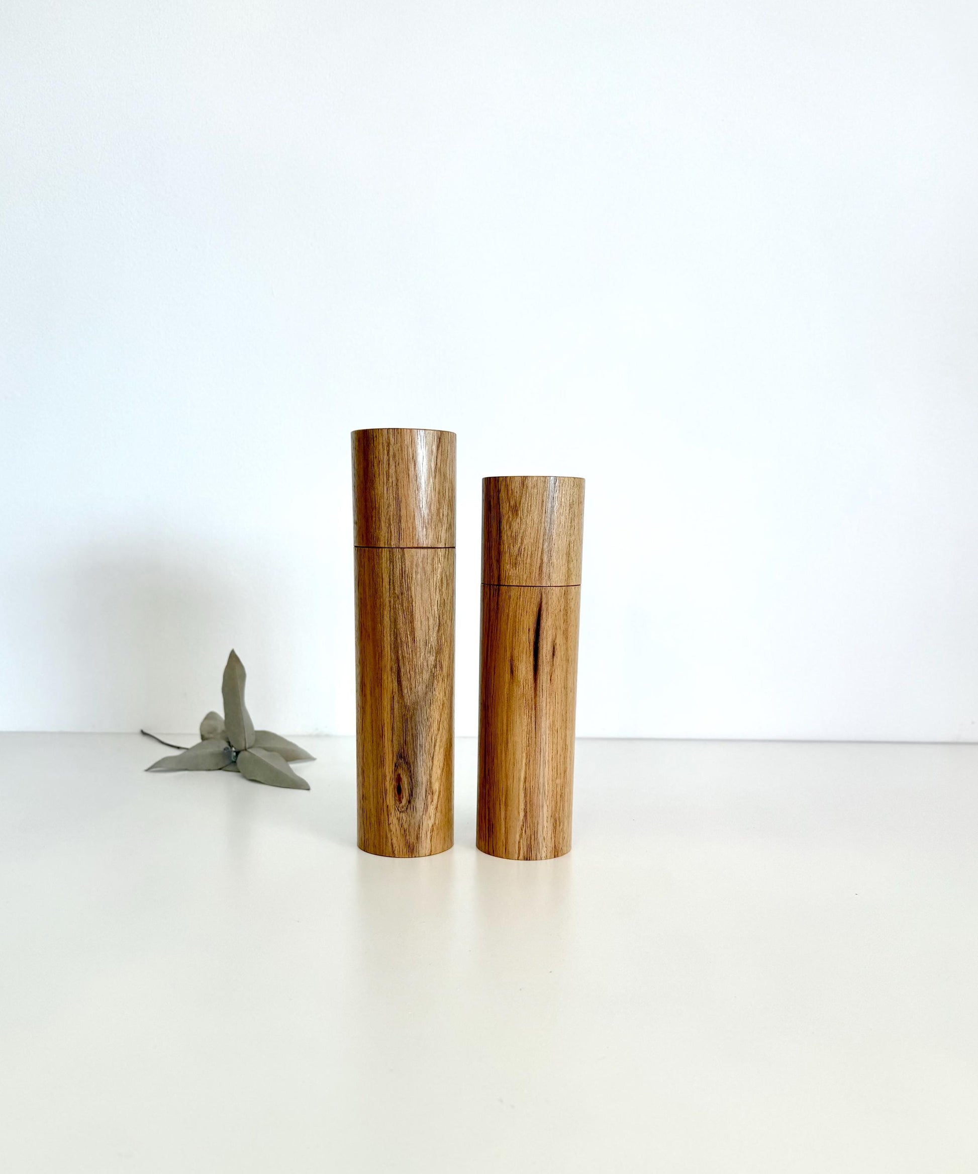 Wooden cylindrical shape salt and pepper grinders made from light brown timber