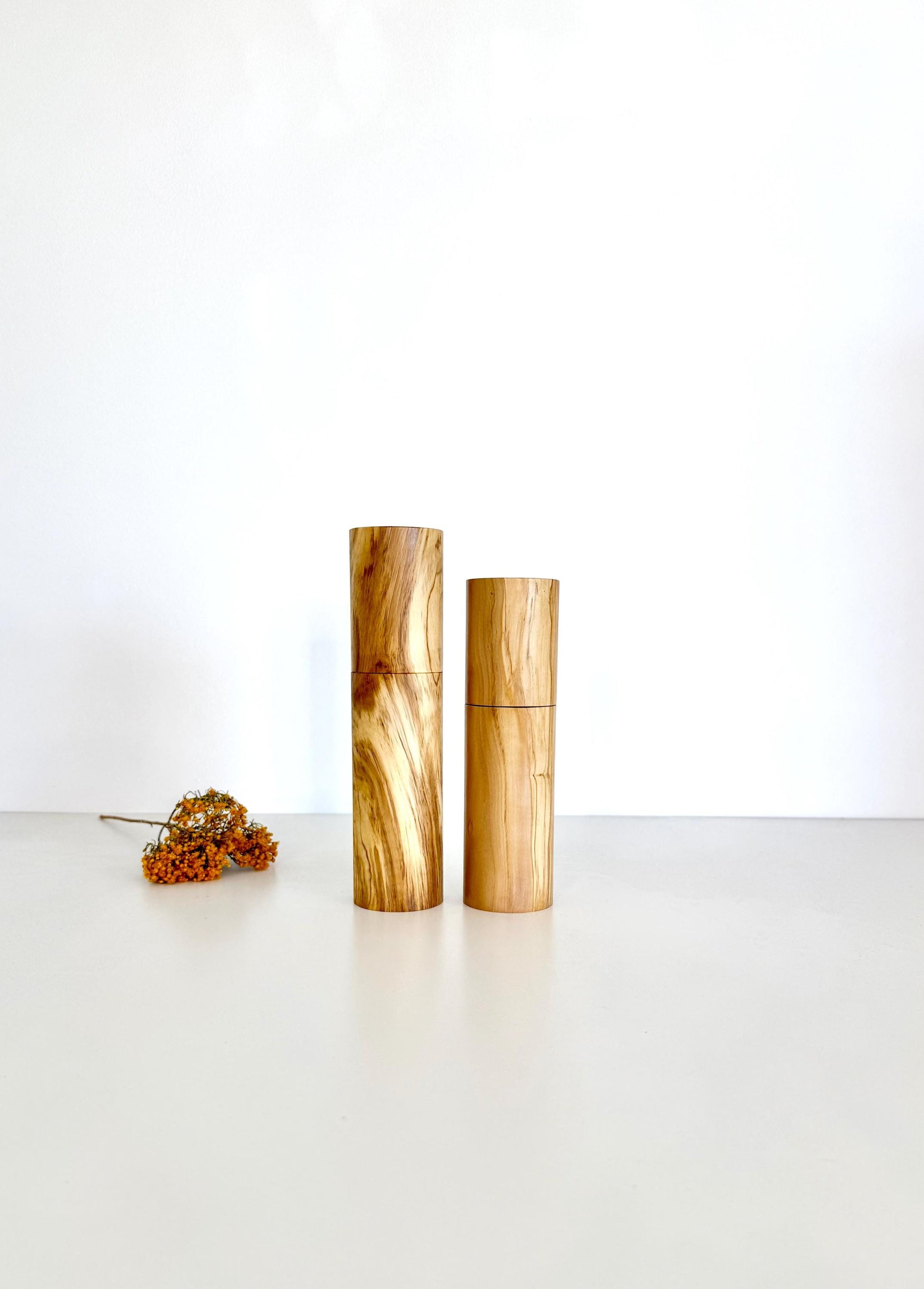 Wooden cylindrical shape salt and pepper grinders made from olive timber