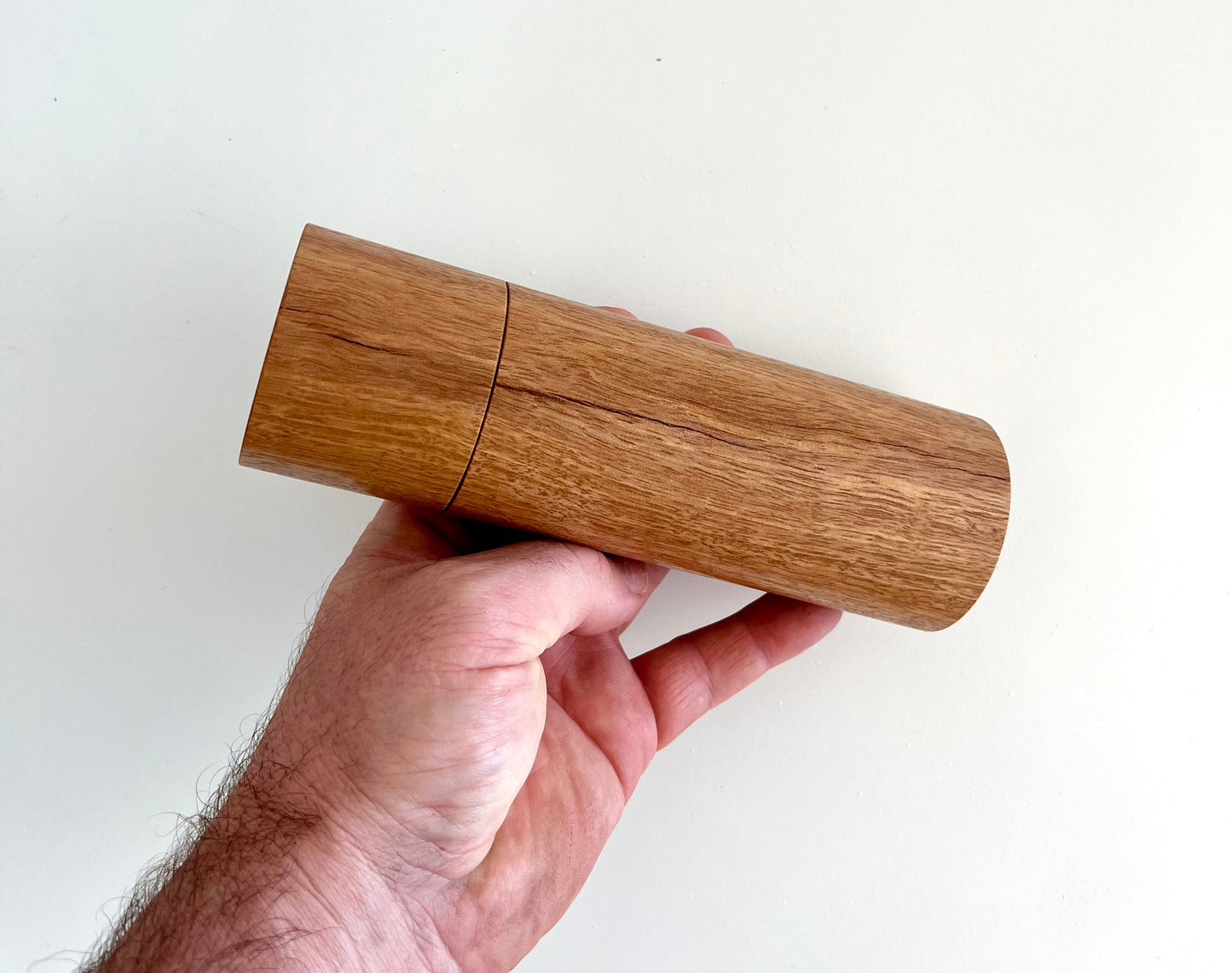 Mans hand hold a Blackbutt grinder on a white background