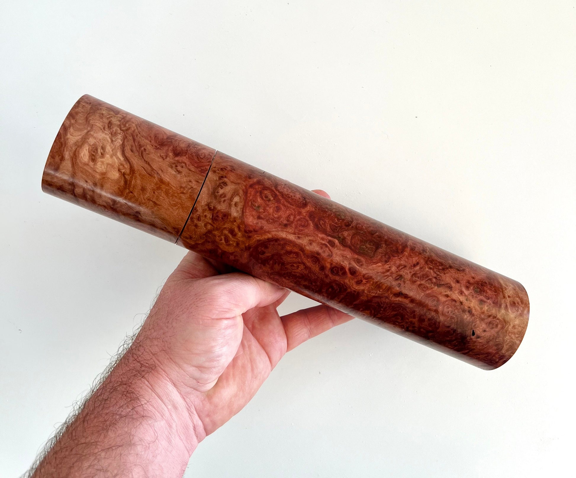 Mans hand holding single straight Red Morrel burl grinder