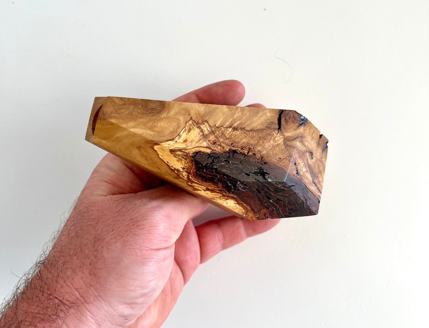 Mans hand holding multi-faceted bud vase made from Australian reclaimed timber